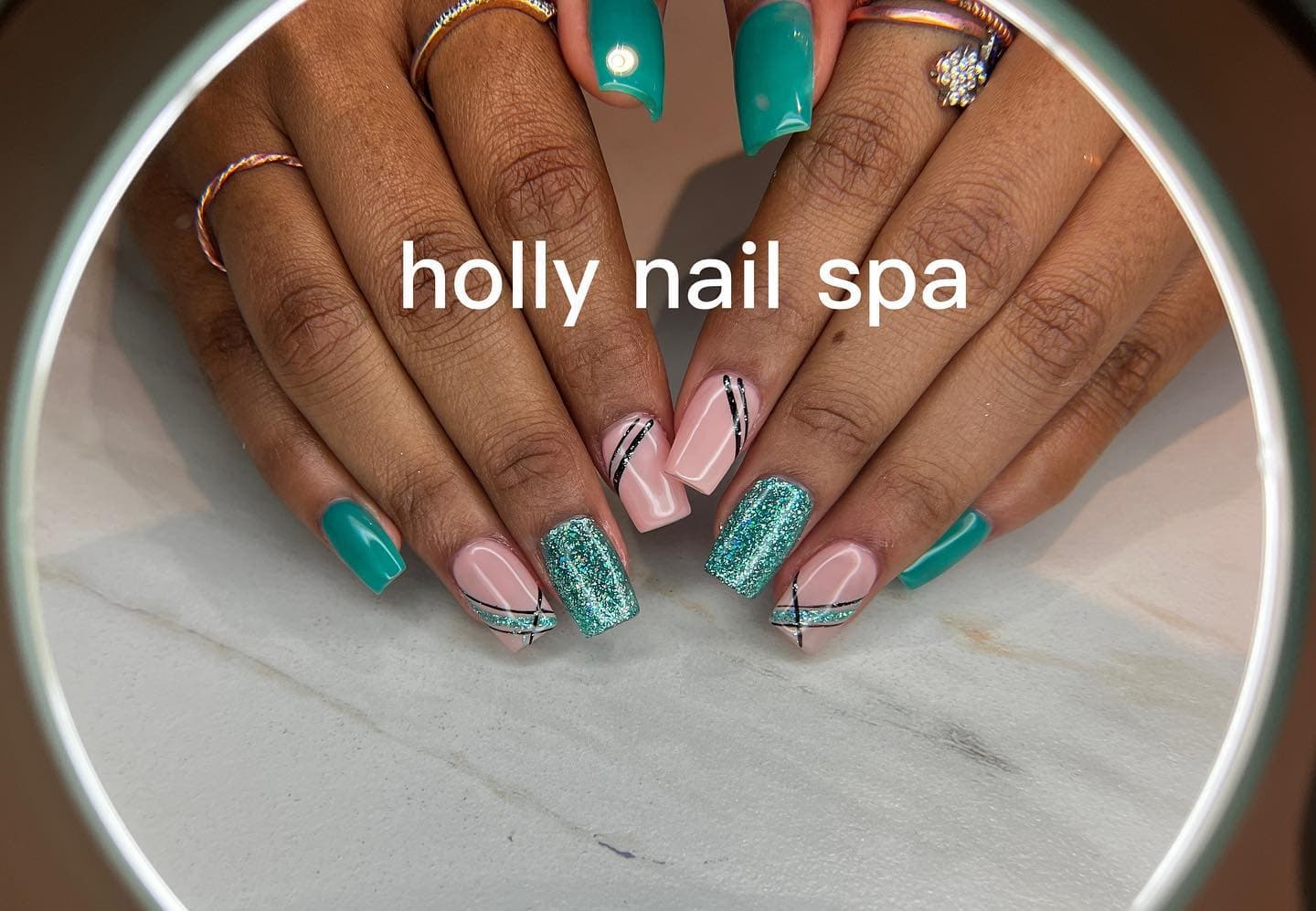 Unghie verde teal con glitter e linee geometriche nere